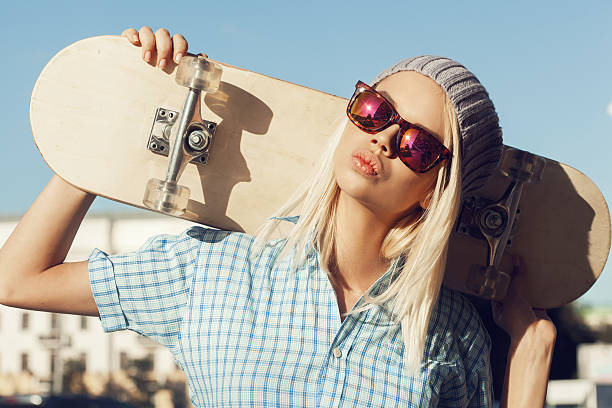 istock Young blond skater girl carrying a skateboard 455197721