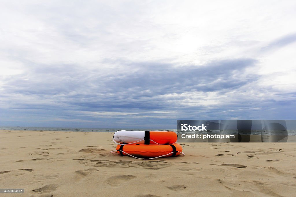Orange lifebuoy lying on the beach Activity Stock Photo
