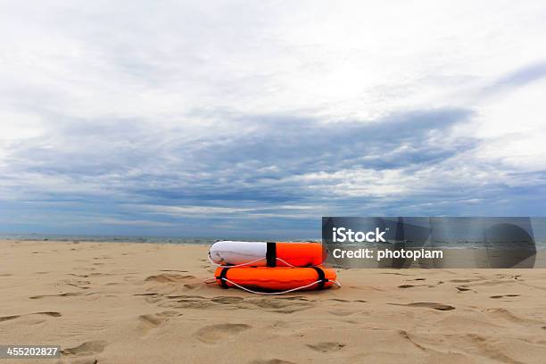 Orange Lifebuoy Lying On The Beach Stock Photo - Download Image Now - Activity, Beach, Blue