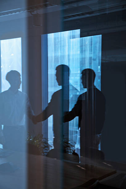 istock Reflection of two businessmen shaking hands 455204819