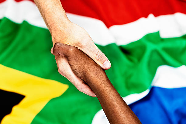 istock No racial tension here: interracial handshake on South African flag 455217015