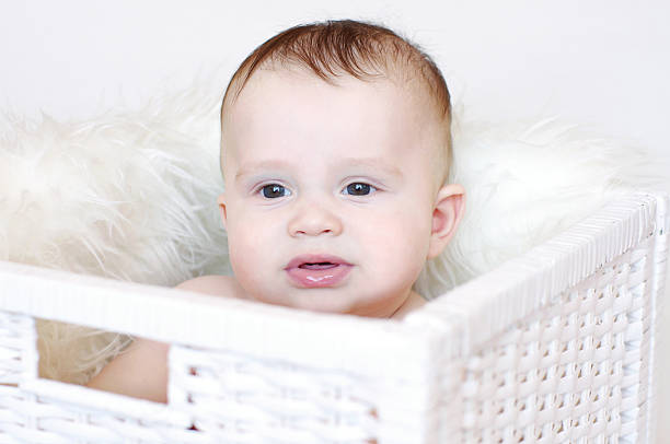 istock Whimsical baby sits in white basket 455235443
