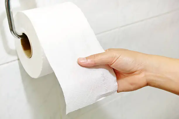 Woman hand holding the roll of toilet paper