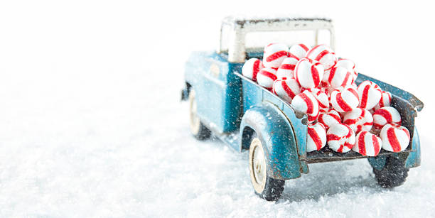 Old toy truck carrying peppermint candy in snowfall