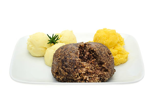 Haggis with neaps and tatties Traditional Scottish haggis meal with neaps and tatties - and a glass of Scotch Whiskey.   Studio shot with a white background. haggis stock pictures, royalty-free photos & images