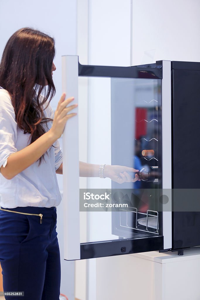 Choosing wine Woman picking chilled wine bottle, fresh out of refrigerator Wine Stock Photo