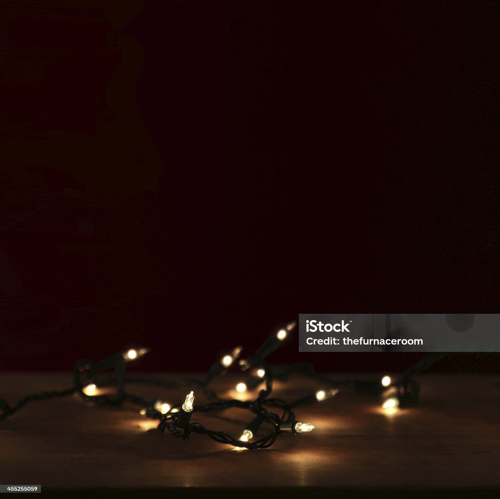 tree lights a tiny ambient string of twinkling lights in a very dark room American Culture Stock Photo