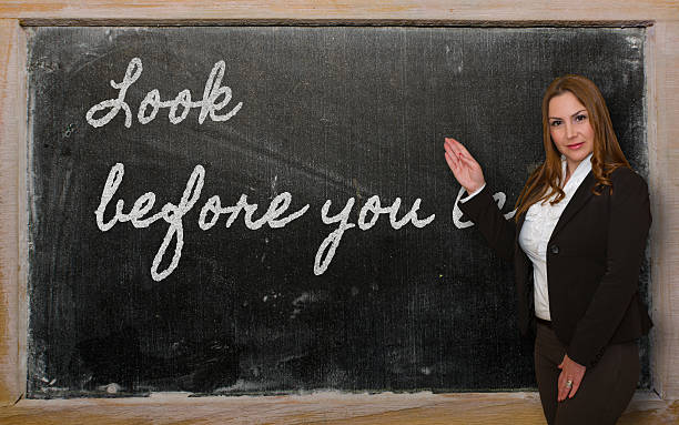 istock Teacher showing Look before you leap on blackboard 455257959