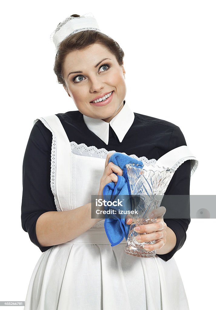 Vintage Maid cleaning vase Portrait of smiling vintage maid cleaning crystal vase. Studio shot, white background. 1920-1929 Stock Photo