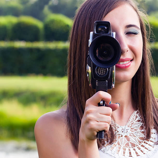 jeune fille souriante avec appareil photo vintage - photographer women retro revival camera photos et images de collection