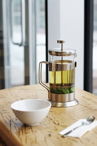 istock French-press with green tea and cup on the wooden table 455272727