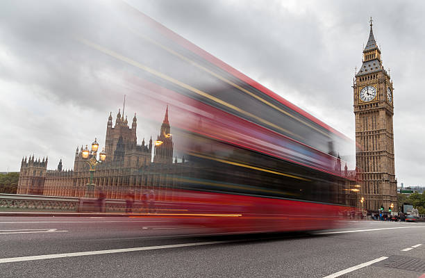 istock Red bus in London speeds past Big Ben 455274955
