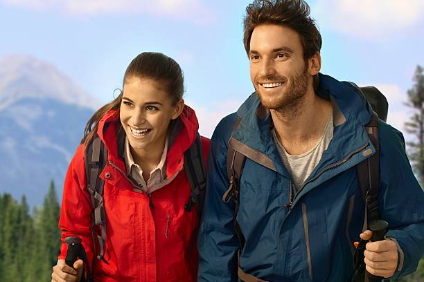 istock Trekking couple climbing uphill smiling. 455275017