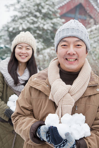 istock Couple Holding snow balls in park 455283847