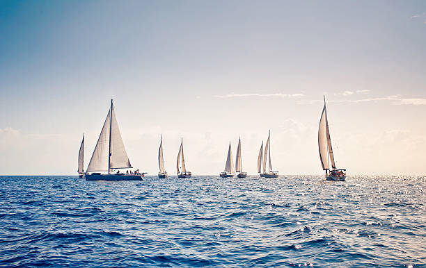 White sail sailing yachts close together in middle of ocean Sailing ship yachts with white sails at the open sea sailboat photos stock pictures, royalty-free photos & images