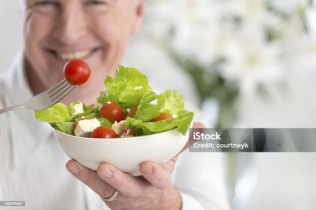 Happy mature man eating salad Happy mature man eating salad focus on salad Eating Stock Photo