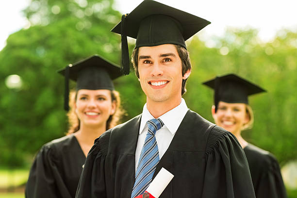 istock Boy Wearing Graduation Gown And Mortar Board At College 455292813