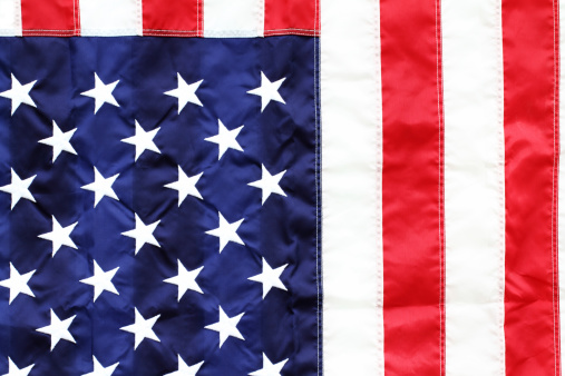 Partial view of USA flag. Red, white and blue, stars and stripes.
