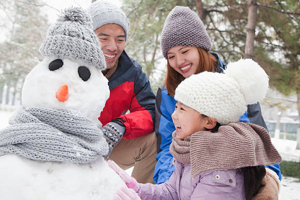 familia haciendo muñeco de nieve en invierno - snowman snow winter fun fotografías e imágenes de stock