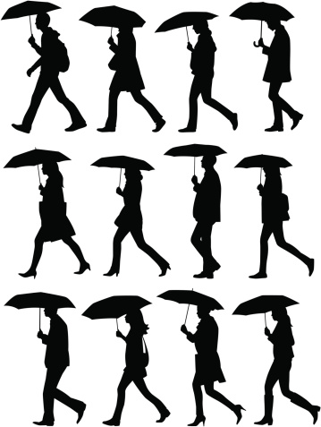 A collection of people walking with umbrellas in silhouette.