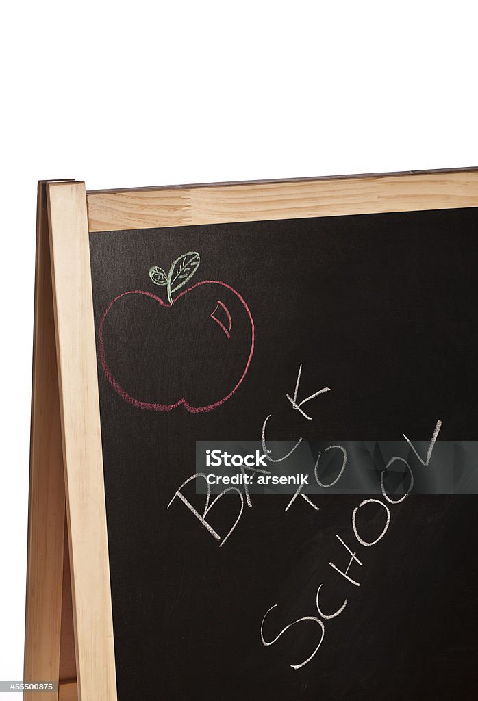 Back to school chalk board "Back to School" written in white chalk with a red chalk illustration of an apple above it on a wood-framed blackboard. Apple - Fruit Stock Photo