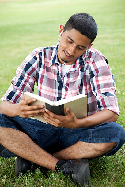 istock Hispanic student reading and listening to music 455528117