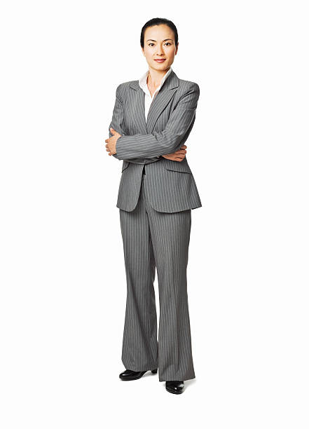 Portrait of a confident senior businesswoman standing with arms crossed isolated over white background. Vertical shot.