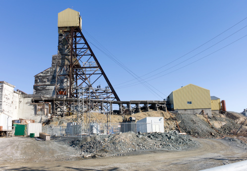 Giant MIne sits abandoned on the edge of the arctic city of Yellowknife, Northwest Territories.   Industrial setting, old buildings and blue sky for copy space.