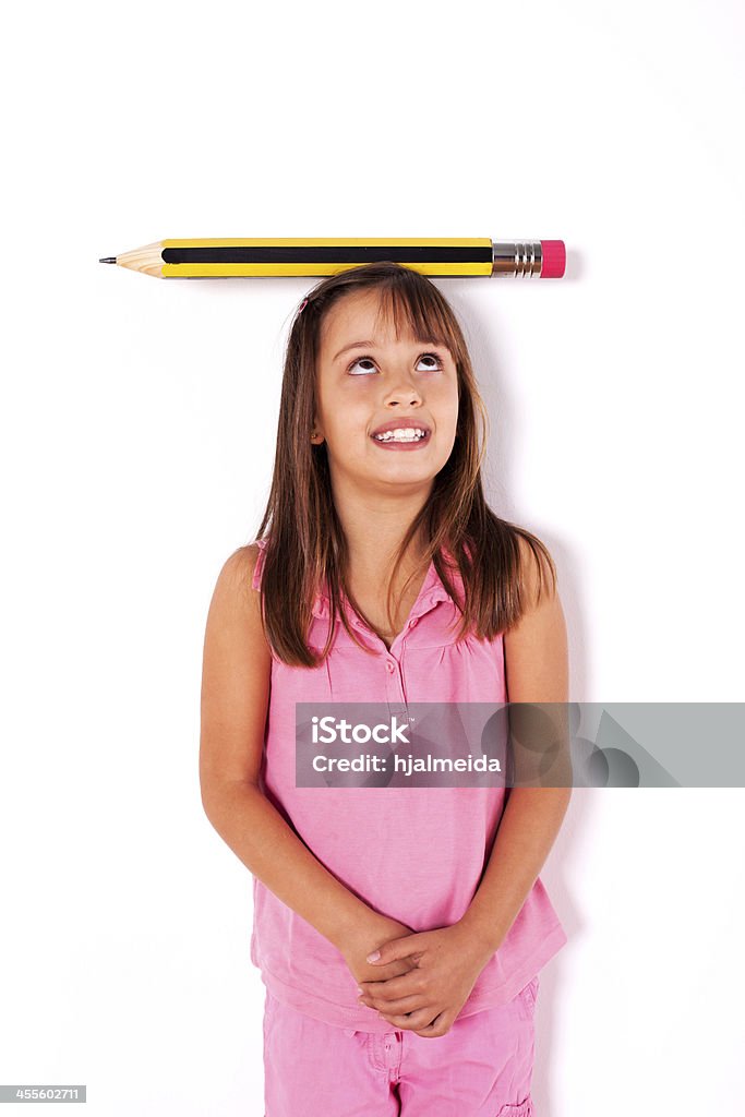 Bambina con un gigante matita sopra la sua testa - Foto stock royalty-free di Abilità