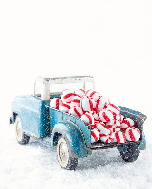 istock Blue toy truck carrying striped peppermint candy 455603291