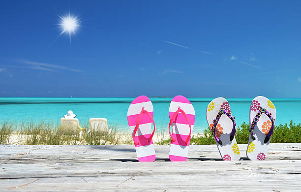 istock Two pairs of flip-flops against Atlantic. Exuma, Bahamas 455606859