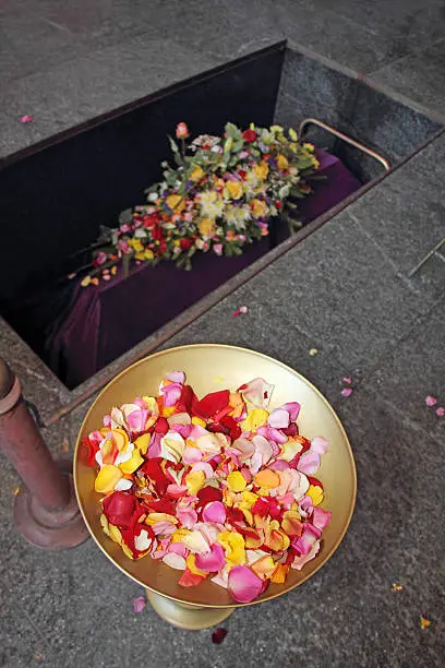 A coffin in a morgue with a flower arrangement