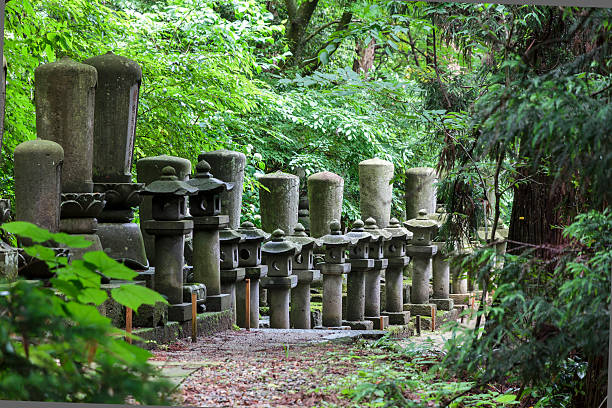 Row of japanese stone lanterns standing in the forest. stock photo