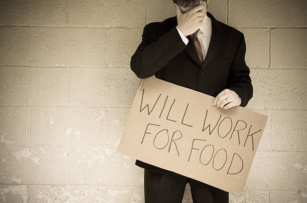 istock Unemployed Businessman Holding Will Work For Food Sign 455611327
