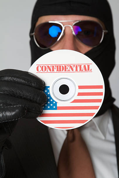 mascherato business uomo di rubare i dati riservati presenti su cd/dvd - business stealing top secret confidential foto e immagini stock