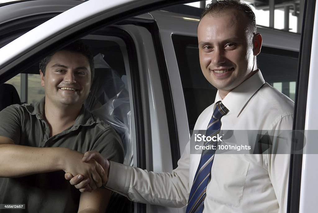 Buying the car Customer and salesperson shaking their hands Adult Stock Photo