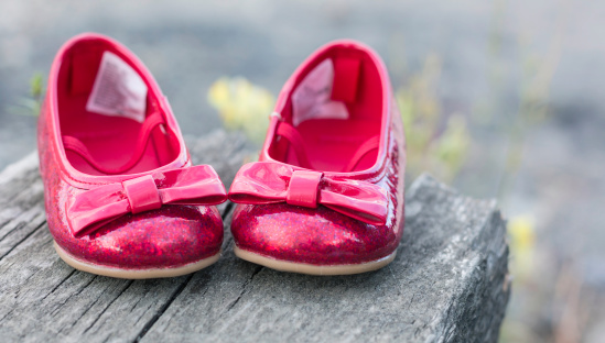 A close-up of pair of ruby shoes for a baby girl.