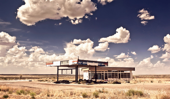 Old gas station in ghost town along the route 66 at border of the desert