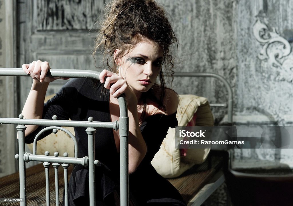 Sad woman Young sad woman sitting on the old bed Adult Stock Photo
