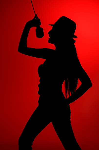 istock silhouette of singing woman in red background 455633721