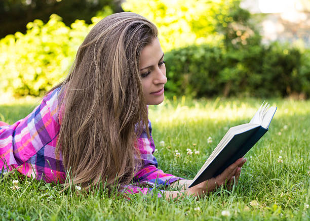 istock Beautiful young female reading a book 455638845