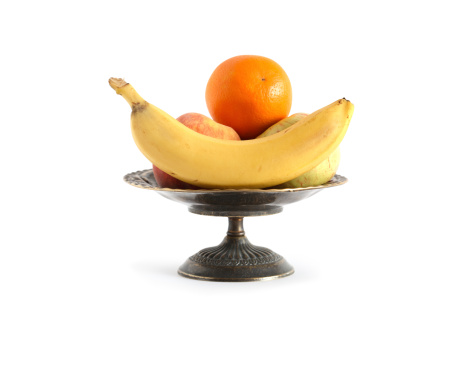 Nice metal fruit bowl full of various fruits on white background. Clipping path is included