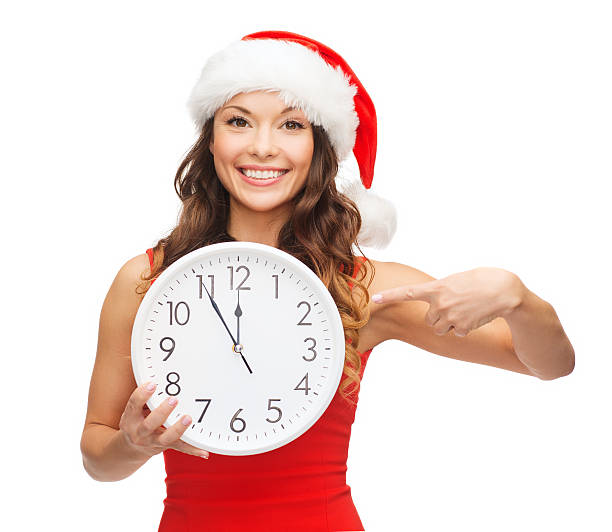 istock woman in santa helper hat with clock showing 12 455663433