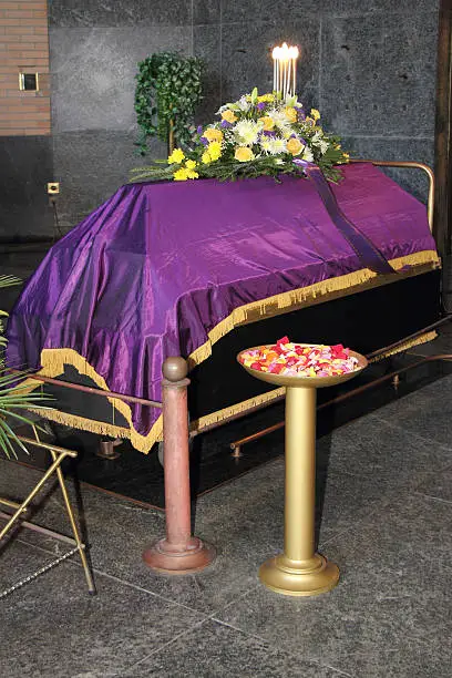 A coffin in a morgue with a flower arrangement