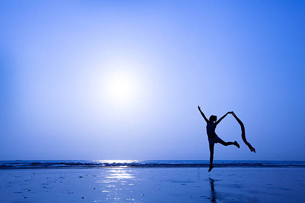 istock Woman dancing in the sand at night 455666917