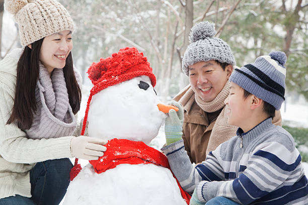 istock Family making snowman in winter 455666943