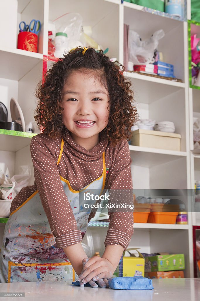Girl Wearing Apron and Playing with Clay Child Stock Photo