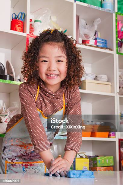 Girl Wearing Apron And Playing With Clay Stock Photo - Download Image Now - Child, Creativity, Clay