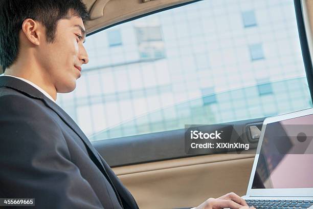 Businessman In Back Seat Of Car Typing On Laptop Stock Photo - Download Image Now - Car Interior, People, 20-24 Years