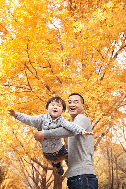 istock Father and Son Playing at Park in Autumn 455669831
